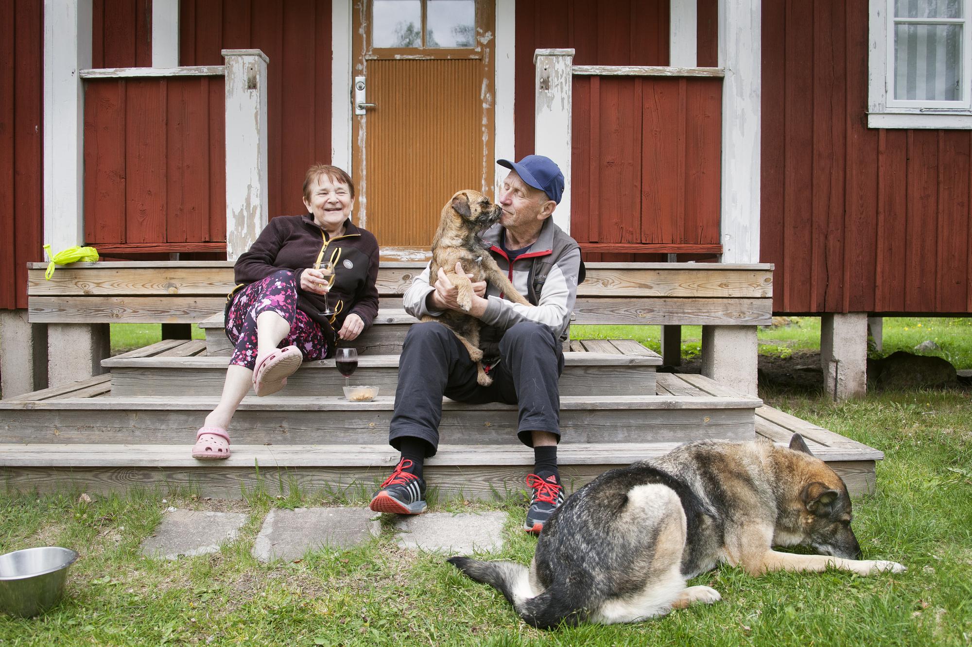 <span>Marieanne Brunnström och Jan-Lennart Andersson på trappen till en av stugorna intill Sågarbo Herrgård med Border Terriern Nutte och Schäfertiken Ixy.</span>